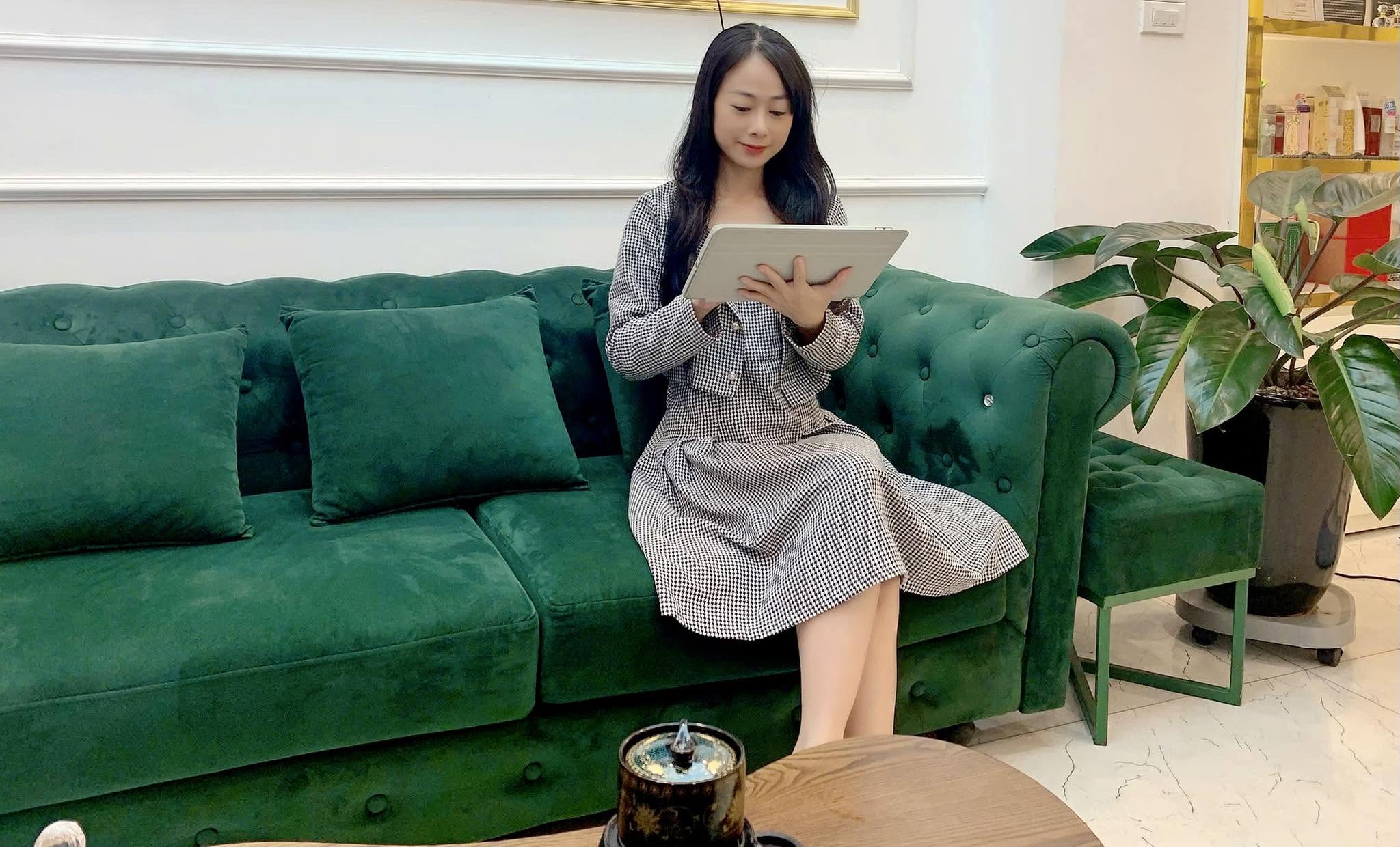Vân Anh đọc sách trên sofa